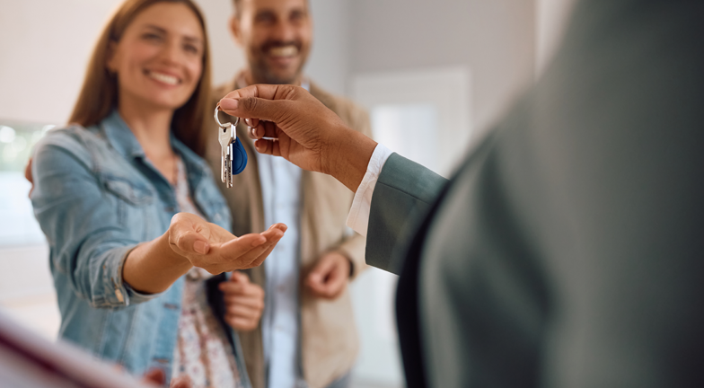 picture of a realestate agent handing over keys to a new homeowner